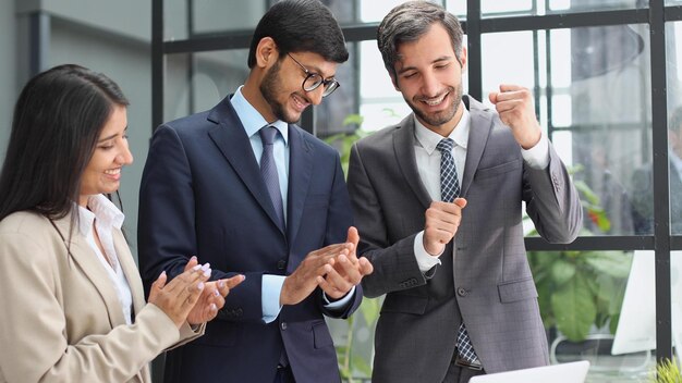 Il team di una società commerciale dà una standing ovation al proprio manager dopo un incontro di successo