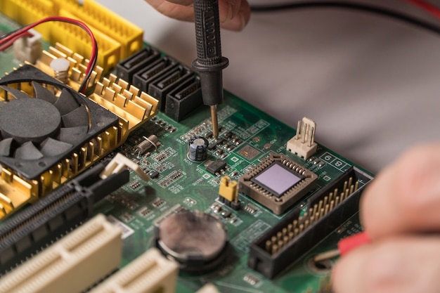 Il tecnico elettronico sta testando un chip per computer. Riparazione PC