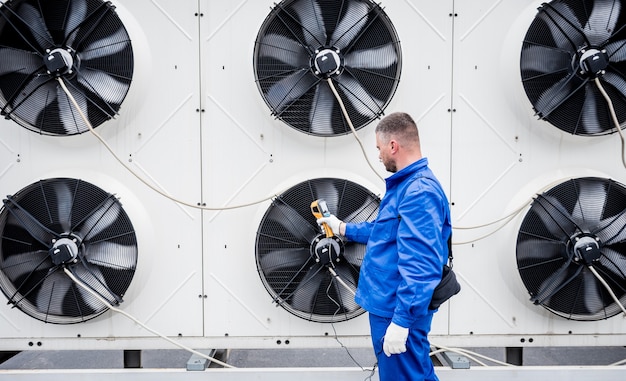 Il tecnico utilizza un termometro a infrarossi per immagini termiche per controllare lo scambiatore di calore dell'unità di condensazione