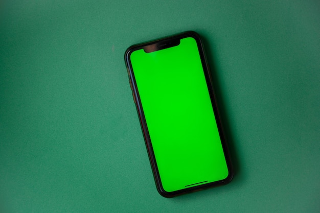 Il telefono con uno schermo verde è su uno sfondo verde foto di alta qualità