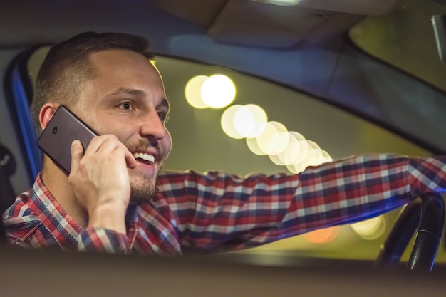 Il telefono dell'uomo d'affari all'interno dell'auto in autostrada. sera notte