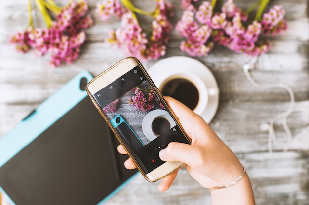 Il telefono in mano prende una tazza di caffè