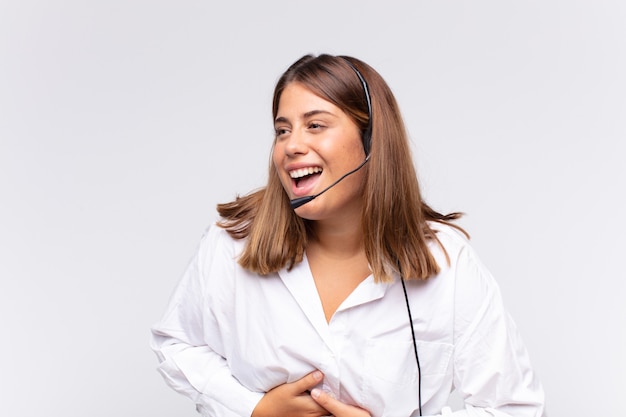 Il telemarketer della giovane donna che ride ad alta voce a uno scherzo esilarante, sentendosi felice e allegro, divertendosi