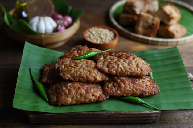 Il tempe bacem è un cibo tradizionale di Java Indonesia servito sul piatto di legno con foglia di banana