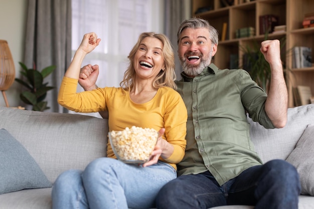 Il tempo libero domestico ha emozionato i coniugi di mezza età che guardano lo sport in TV a casa