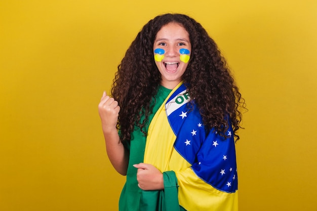 Il tifoso di calcio brasiliano della ragazza caucasica ha stretto il pugno urlando di sì per celebrare la vittoria del Brasile