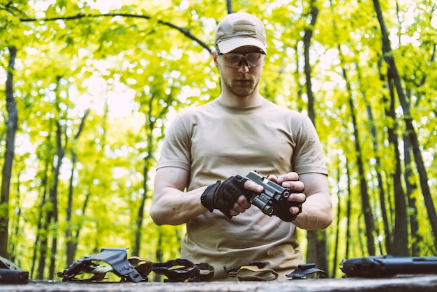 Il tizio nel bosco prova le sue armi per le sparatorie sportive.