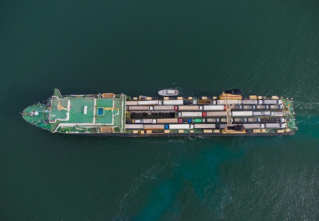 Il traghetto per auto trasporta i camion nella vista aerea del mare