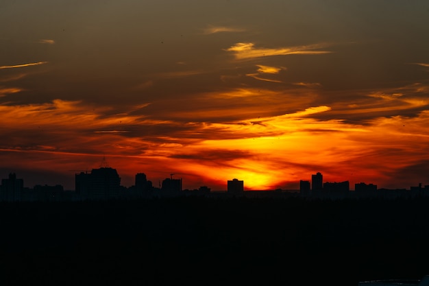 Il tramonto arancio sopra la città coperta da si rannuvola Minsk, la Bielorussia.