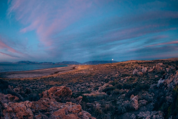 Il tramonto nelle colline vicino al lago lapida la valle della luna della roccia