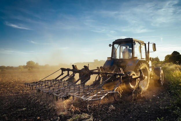 Il trattore ara la terra. Immagine dell'agricoltura