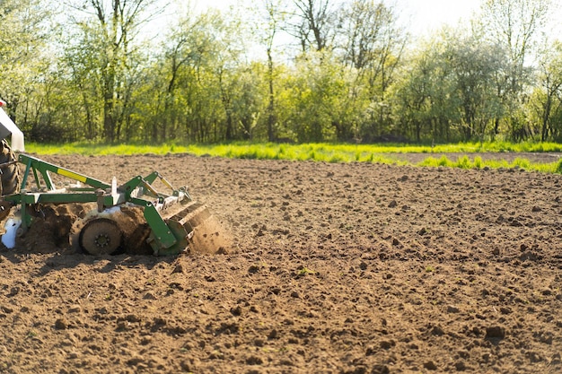 Il trattore attraversa il campo e coltiva la terra