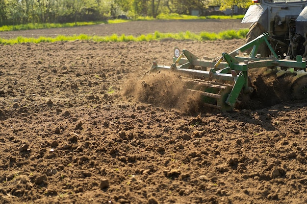 Il trattore attraversa il campo e coltiva la terra