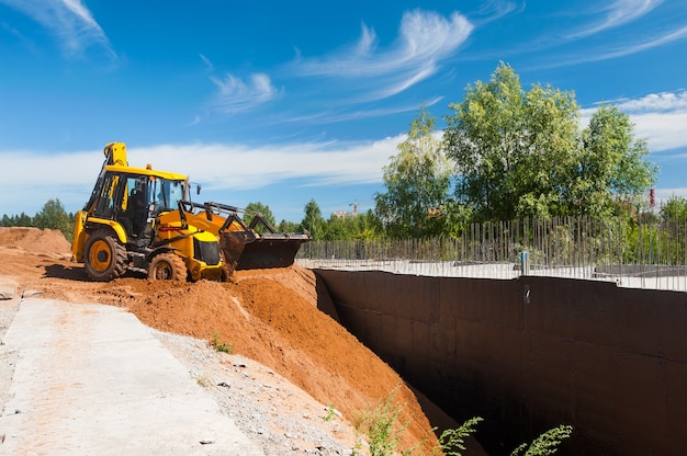 Il trattore livella il terreno in cantiere Lavori di sterro