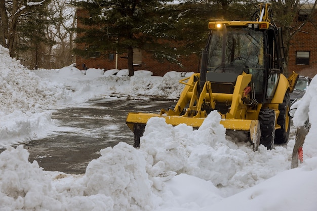 Il trattore per lo sgombero della neve apre la strada dopo la nevicata.