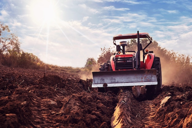 Il trattore sta coltivando il terreno, preparando il terreno per l'agricoltura.