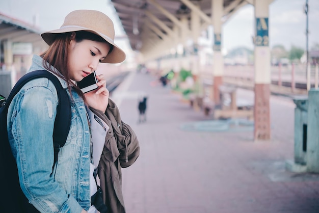 Il treno asiatico di attesa del turista alla stazione ferroviaria dell'uomo dei pantaloni a vita bassa della Tailandia va a viaggiare