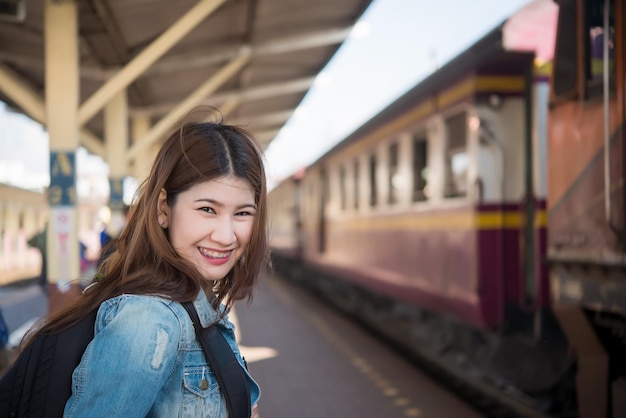 Il treno asiatico di attesa del turista alla stazione ferroviaria dell'uomo dei pantaloni a vita bassa della Tailandia va a viaggiare