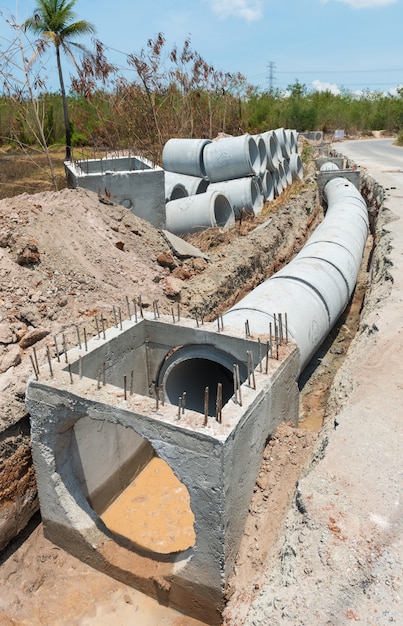 Il tubo concreto di drenaggio del canale sotterraneo e la linea di tubo concreta di fila su un cantiere