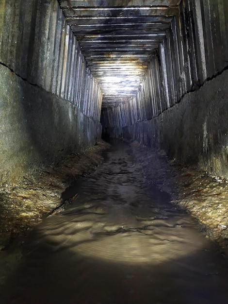 Il tunnel del collettore fognario sotterraneo con pareti nervate in prospettiva