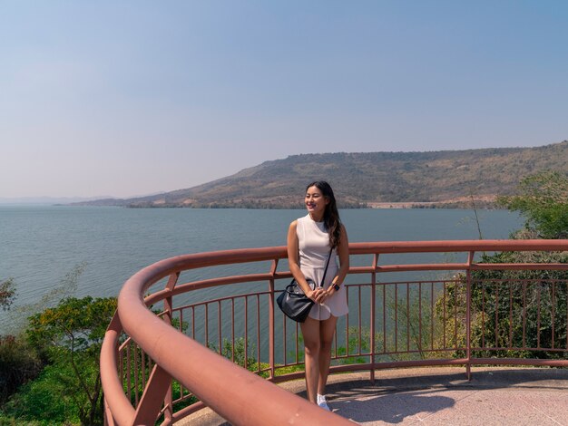 Il turista asiatico felice della donna si rilassa alla terrazza del punto di vista della diga di Lamtakong, destinazione di viaggio a Nakhon Ratchasima, Tailandia