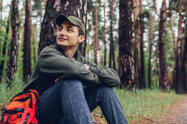 Il turista felice dell&#39;uomo che riposa nella foresta di primavera Il viaggiatore si è fermato per rilassarsi accampandosi, viaggiando