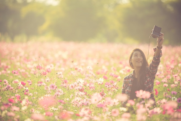 Il turista femminile abbastanza giovane prende il selfie di viaggio al giacimento di fiore dell&#39;universo