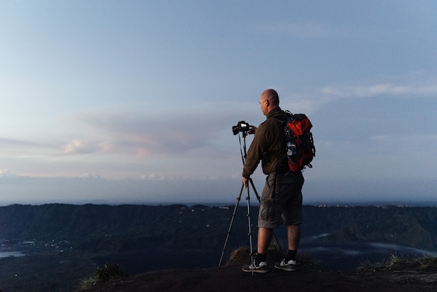 Il turista fotografo monta la sua macchina fotografica su un treppiede per la fotografia di paesaggio