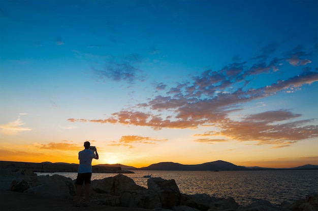 Il turista scatta una foto ad Alghero al tramonto