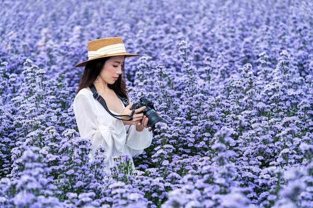 Il turista scatta una foto con la fotocamera digitale nei campi di fiori di Margaret.