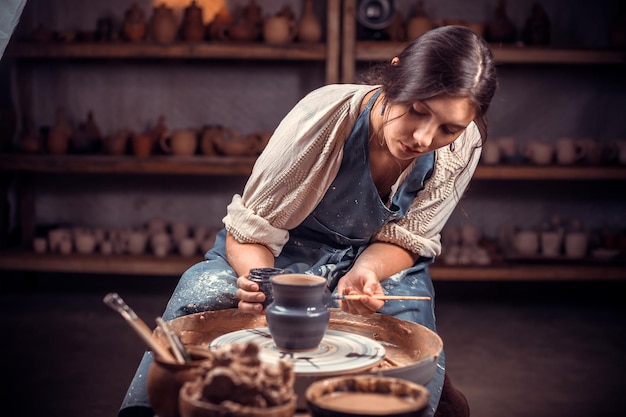 Il vasaio lavora su un tornio da vasaio. Concetto: fatto a mano, officina, ceramica.