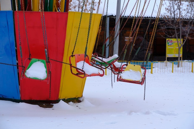 Il vecchio carosello a catena retrò rimane inattivo in inverno coperto di neve