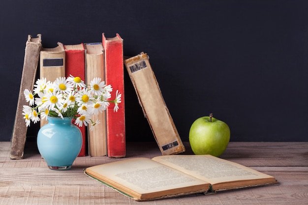 Il vecchio libro d&#39;annata aperto si trova su una tavola rustica di legno. Paese ancora vita.