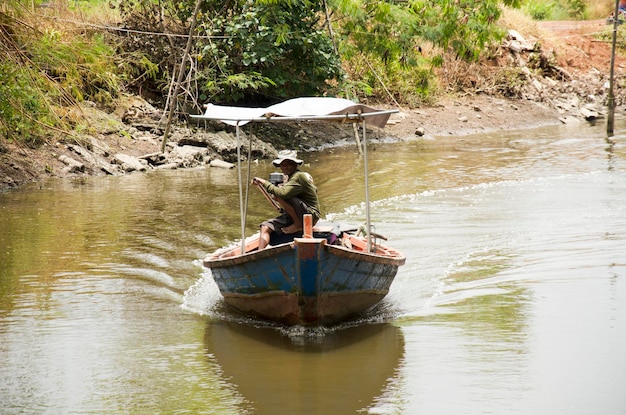 Il vecchio tailandese che guida la barca a coda lunga porta la gente a visitare la riva del fiume e la foresta di mangrovie della città di Pak Nam Prasae il 10 agosto 2016 a Rayong Thailandia