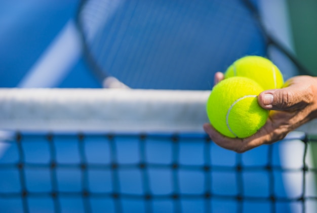 il vecchio tiene due palline da tennis nella mano sinistra