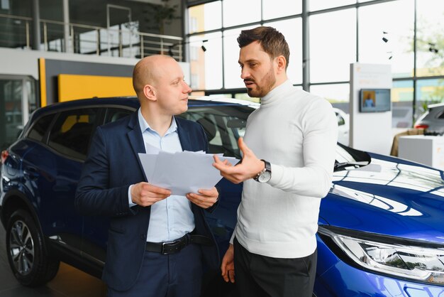 Il venditore e l'acquirente nel salone dell'auto