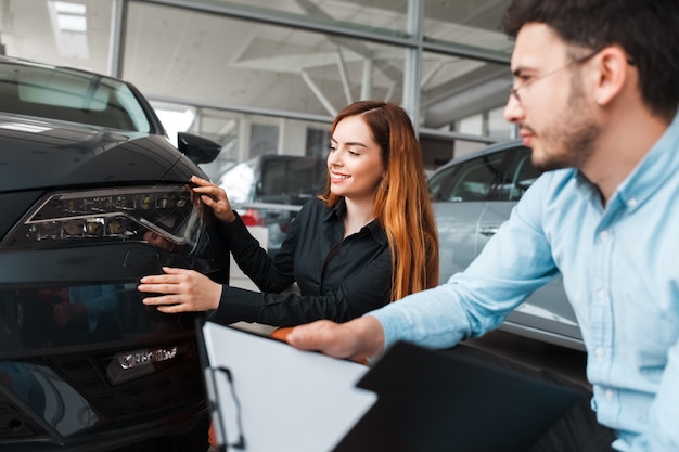 Il venditore mostra l'auto a un giovane cliente