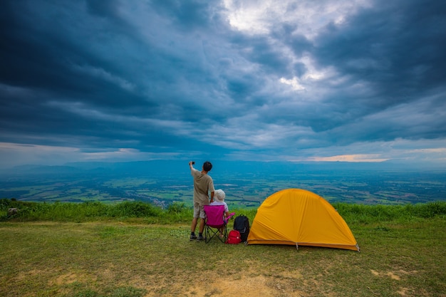 Il viaggiatore con la sua tenda sulla scogliera di sera.