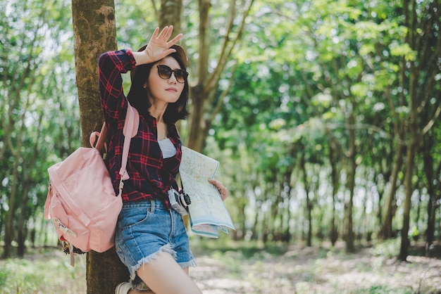 Il viaggiatore femminile asiatico che stanca da ha perso la sua direzione in foresta