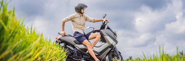 Il viaggiatore maschio su una bici fra un turista del campo di riso viaggia al formato lungo dell'insegna di bali