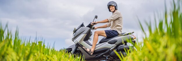 Il viaggiatore maschio su una bici fra un turista del campo di riso viaggia al formato lungo dell'insegna di bali