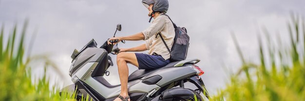 Il viaggiatore maschio su una bici fra un turista del campo di riso viaggia al formato lungo dell'insegna di bali