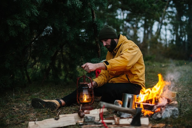 Il viaggiatore usa una lampada a cherosene Allestisce un rifugio nella foresta per la notte