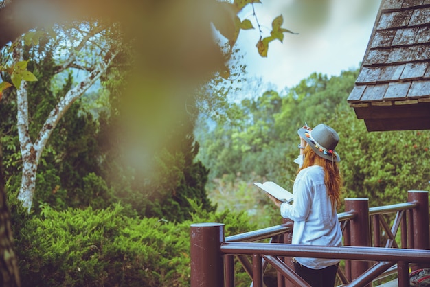 il viaggio asiatico della donna si distende. Parco Naturale. In piedi leggi un libro sul balcone del lodge.