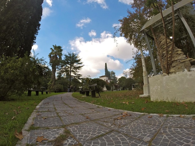 Il vialetto piastrellato attraversa il verde giardino del parco verso la casa