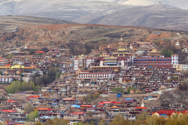 Il villaggio inclose la montagna un punto di riferimento famoso in Ganzi, Sichuan, Cina.