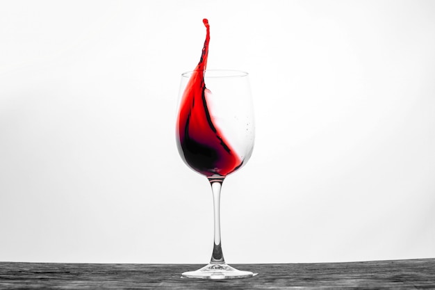 Il vino rosso nel bicchiere spruzza in movimento