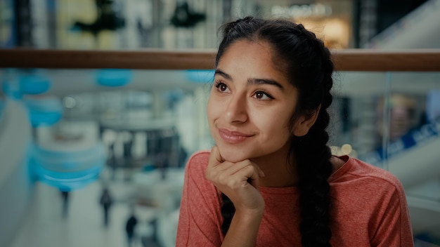 Il visitatore attraente dell'acquirente della studentessa araba si siede al sogno sorridente della donna del centro commerciale della barra del caffè