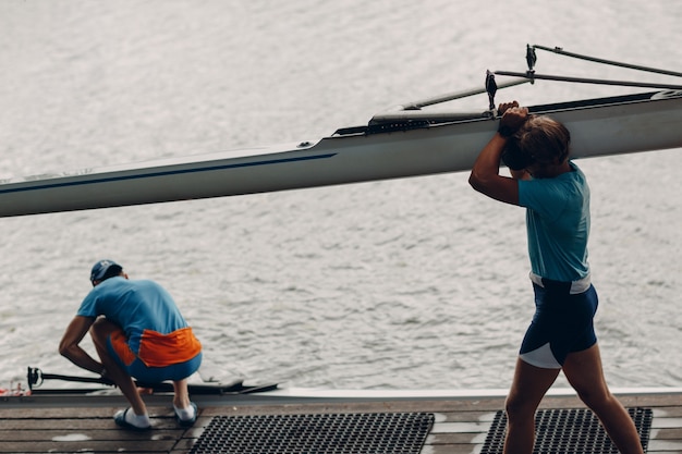 Il vogatore uomo di coppia sportiva si prepara alla competizione con la barca