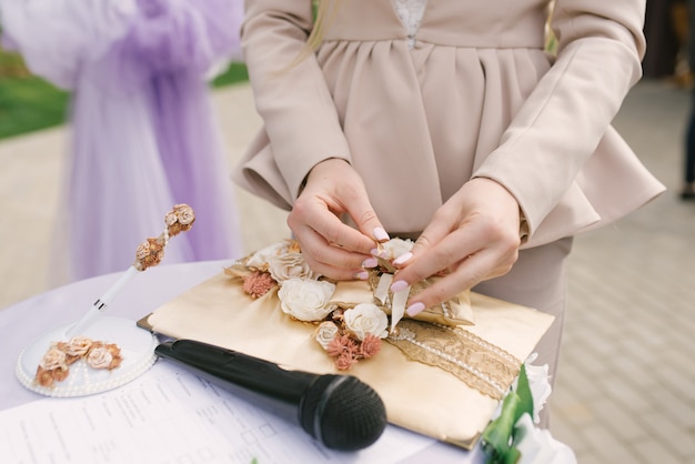 Il wedding planner mette le fedi nuziali sul cuscino. La cerimonia del matrimonio